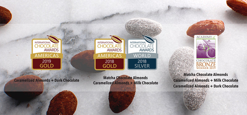 Chocolate Almonds on marble surface, International Chocolate Award and Academy of Chocolate Award Badges in foreground